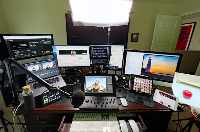Dual monitor broadcaster desk setup with audio mixer and macro controller for live streaming